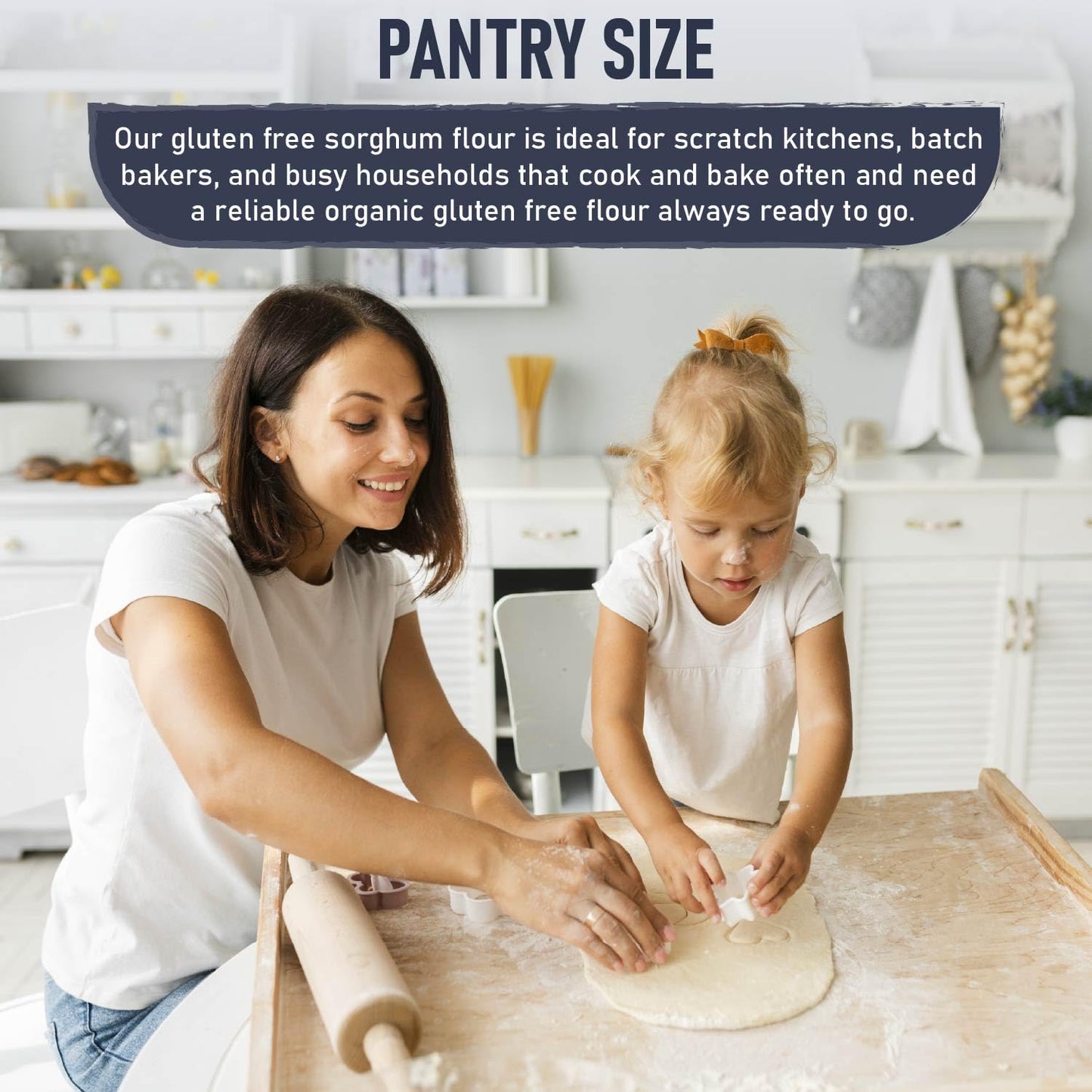 A woman and a young child in a bright kitchen roll out dough on a wooden surface. A rolling pin and flour are visible, with a sign above reading "Pantry Size."