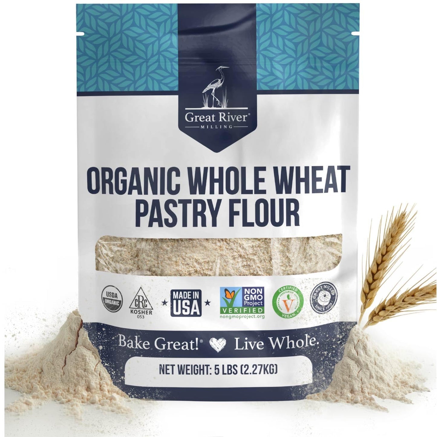 A 25 lb bag of Great River Milling Organic Whole Wheat Pastry Flour features a blue and white design with certification logos and a clear window showing the flour