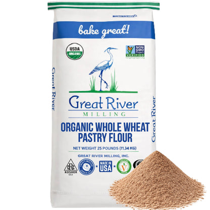 A 25 lb bag of Great River Milling Organic Whole Wheat Pastry Flour, featuring a crane illustration and certification logos, with a mound of flour in the foreground