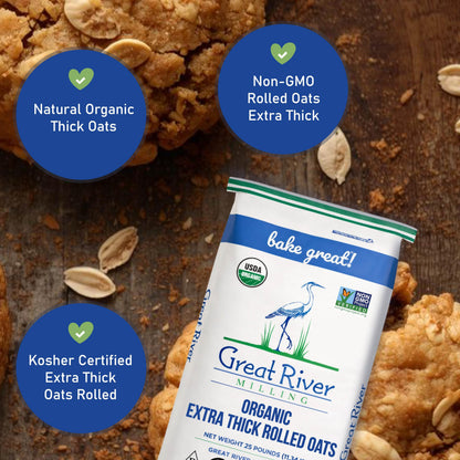 A 25 lb bag of Great River Milling Organic Extra Thick Rolled Oats is displayed against a background of freshly baked oat cookies. The packaging highlights its non-GMO and kosher certifications