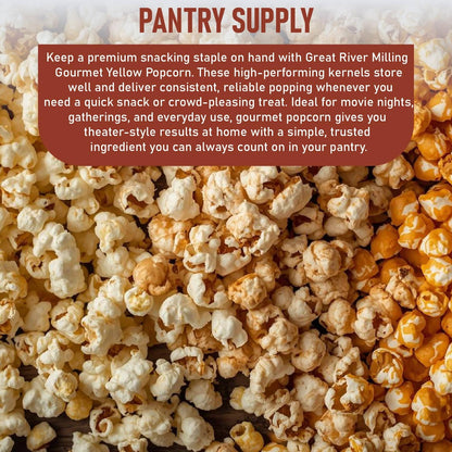 A close-up view of fluffy, golden popcorn scattered across a wooden surface. The popcorn is labeled as Great River Milling Gourmet Yellow Popcorn