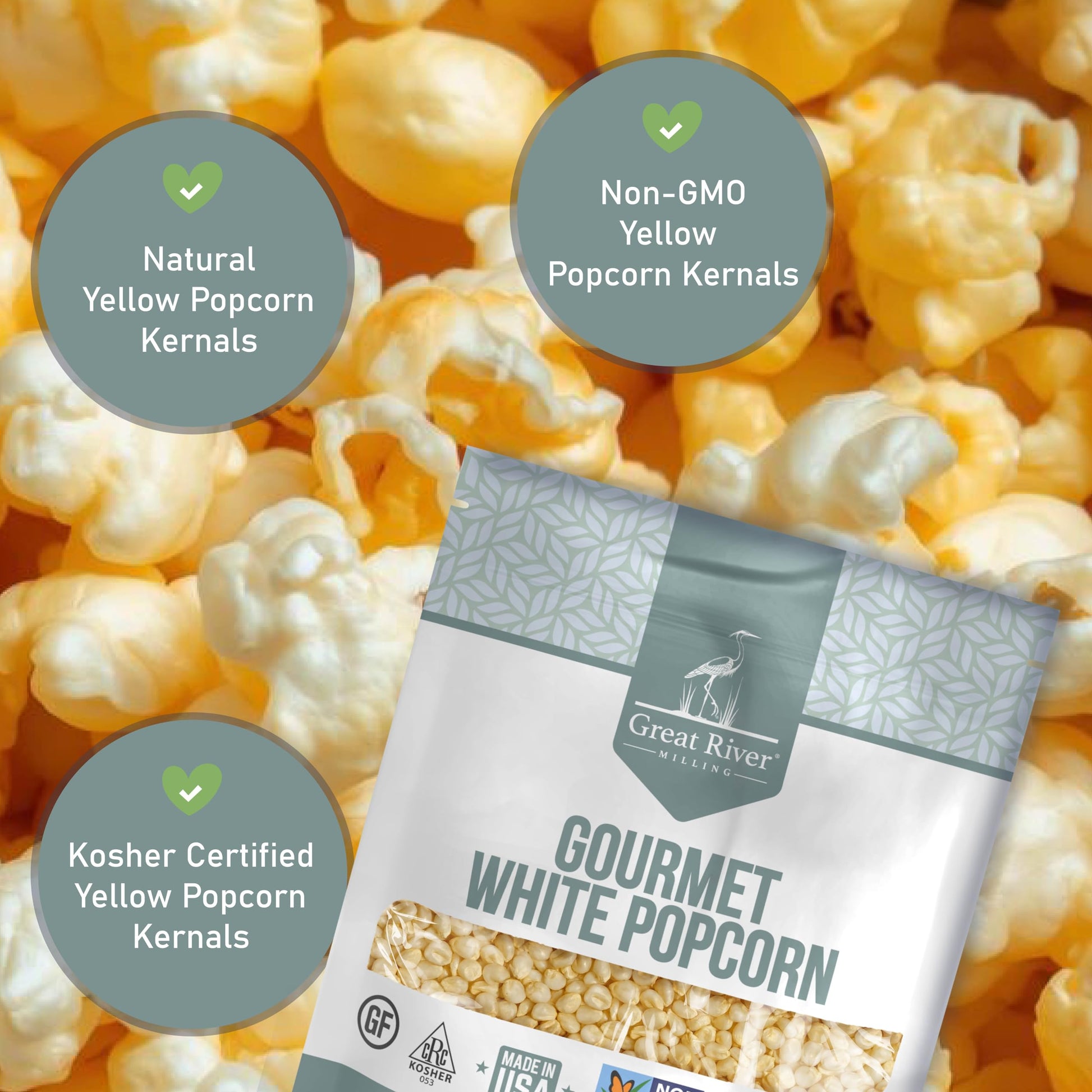 A package of Great River Milling Gourmet White Popcorn Kernels is set against a backdrop of popped yellow popcorn. The bag features a gray geometric pattern and various certification icons